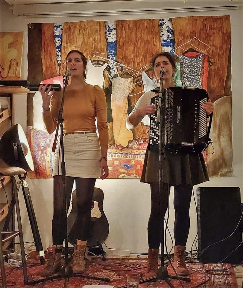 Alissia and Morgane from Lyonesse on stage with shaker, accordion and voices.